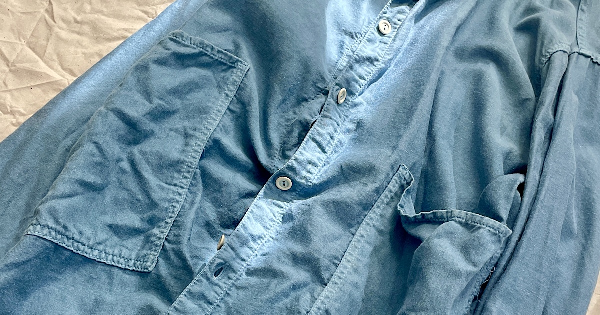 ライトブルーのシャツの襟ボタンのアップ画像