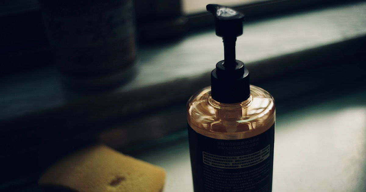 窓際のボディーソープの入ったボトルとスポンジが置かれた様子