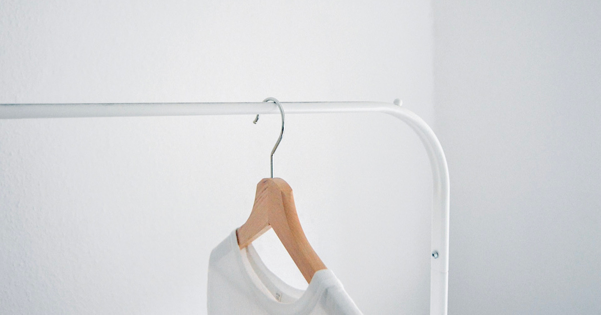 白いラックに掛けられた一枚の白いTシャツ