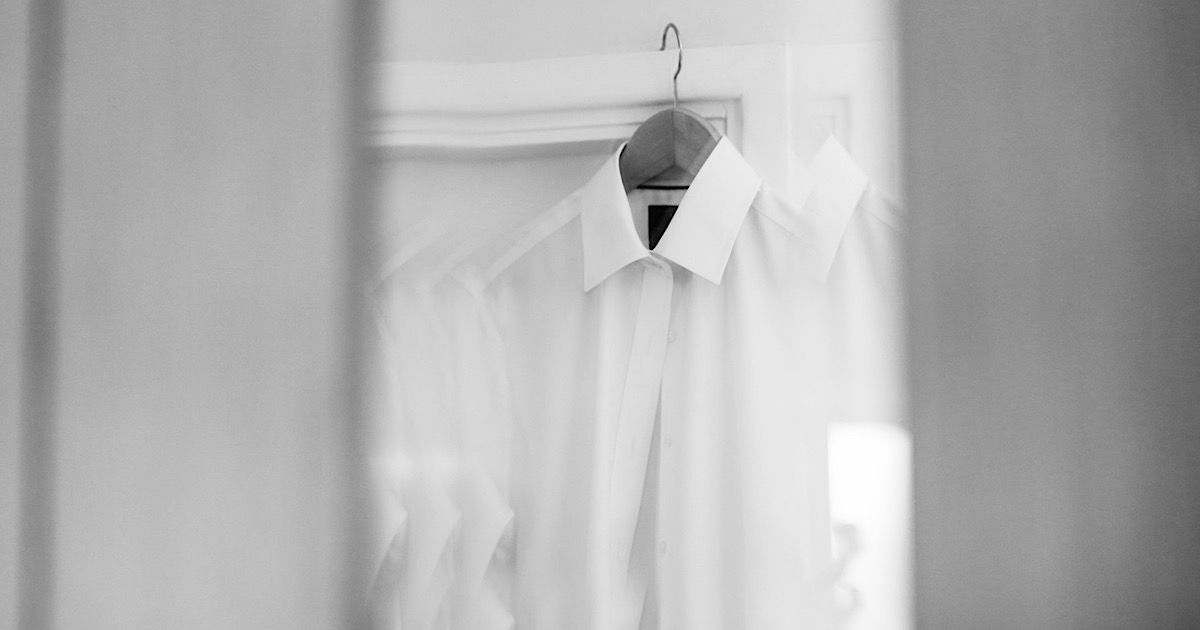 ラックに掛けられた白のドレスシャツ