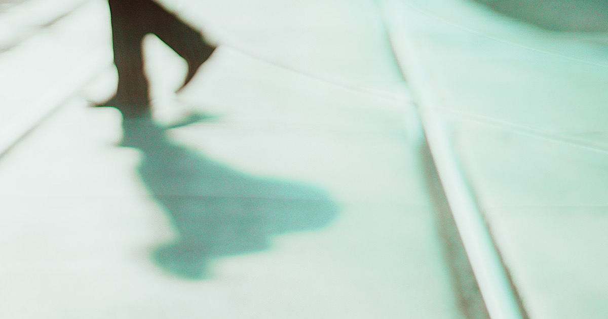 歩いている人の足元と影