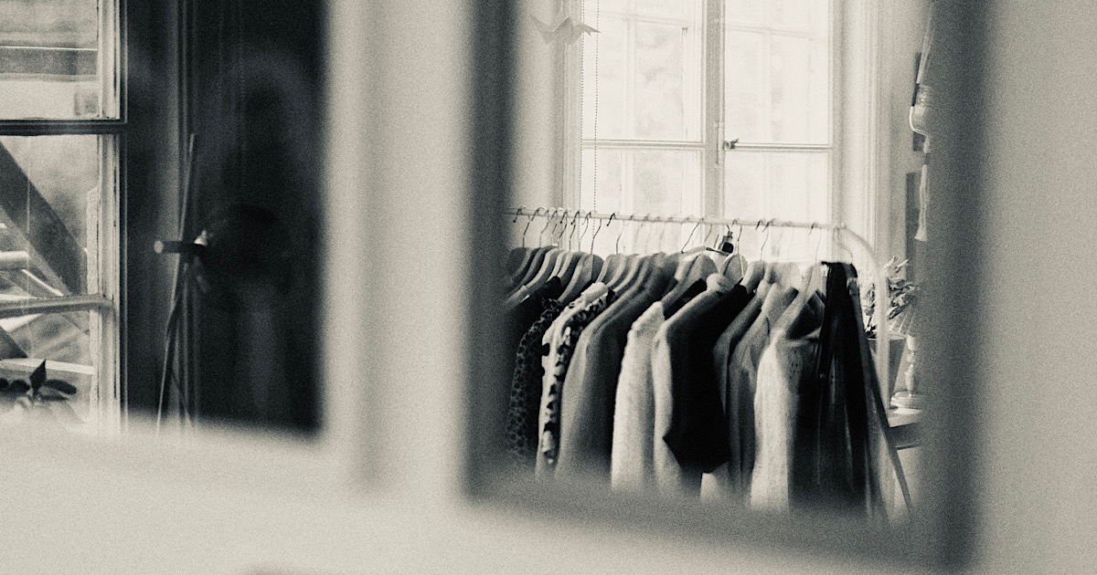 鏡に映り込んだ洋服が掛かったラック