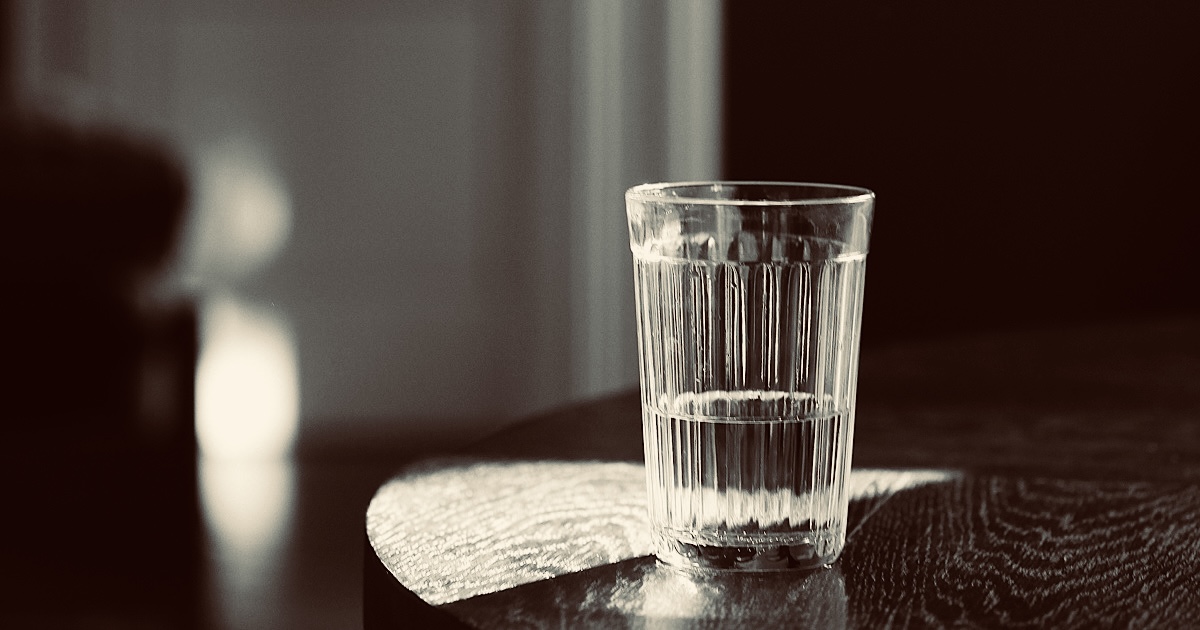 テーブルの上に置かれた水の入ったグラス