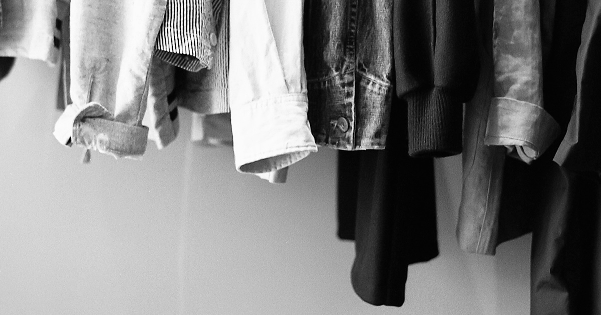 ラックに掛かった洋服の袖口を映した様子