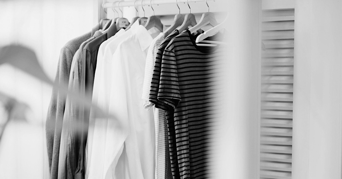 ラックに掛けられた白いシャツやTシャツの様子