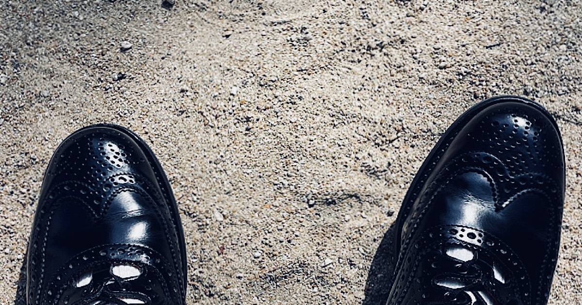 砂の地面で革靴の先端を撮影した様子