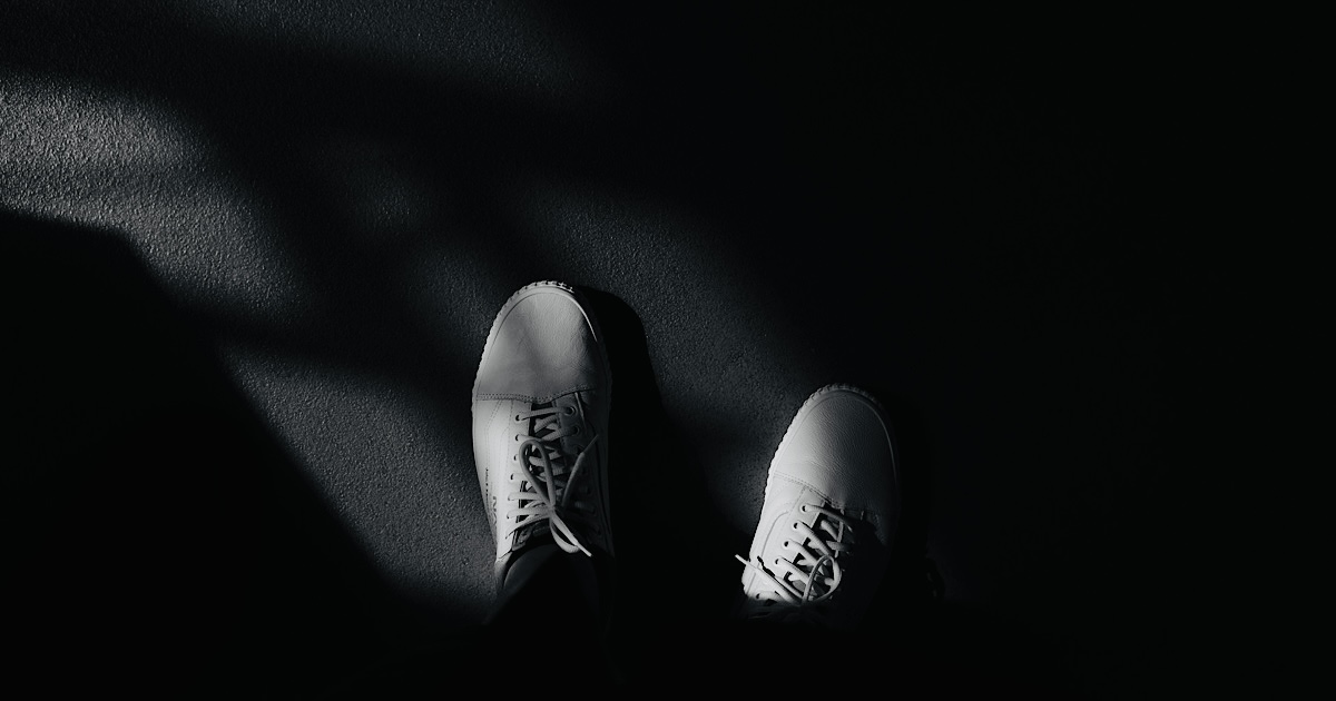 自分が履いた白のスニーカー上から見下ろす様子