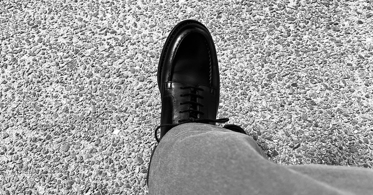 革靴を履いた片足を上から見下ろす様子